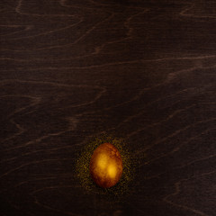 Wall Mural - Golden easter egg on wood