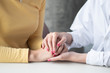 © 9nong - female doctor or woman medical staff holding hand, working hand in hand, giving encouragement to patient or relative of patient; concept of woman health care worker, doctor, therapist, medical worker