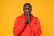 © ViDi Studio - Shocked young african american man guy in red streetwear hoodie posing isolated on yellow orange background studio portrait. People lifestyle concept. Mock up copy space. Covering mouth with hands.