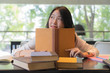 © ijetdo - Beautiful student wearing white shirt reading books on the table in library