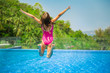 © Suzi Media  - Excited funny little girl jumping to the swimming pool. Happy summer vacation