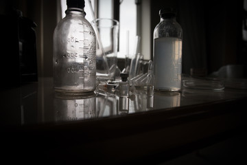 medical glass in school laboratory in front of window. Dark Room