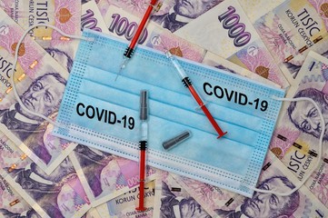 Medical viel laid on Czech money. Syringes are placed on the veil.