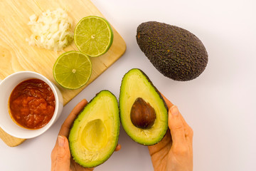 Wall Mural - Avocado cut with a lime, tomato and onion sauce. Recipe to prepare a nice guacamole