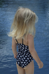 adorable blonde toddler girl enjoying day at the pool. summer vacation concept.