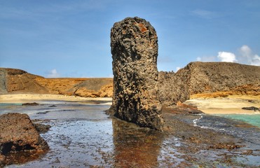 Wall Mural - Big, tall standing boulder on a beach in Djeu