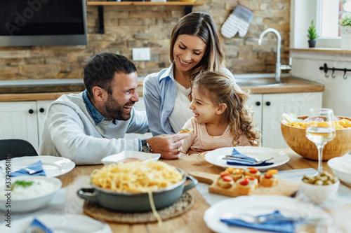 Fotografía Happy parents and theirs mall daughter having fun during family lunch at home