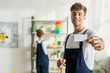 © LIGHTFIELD STUDIOS - selective focus of happy and handsome cleaner holding blank card