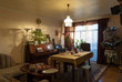 © Hernandez And Sorokina/ADDICTIVE STOCK - Interior of typical simple cozy living room decorated for Christmas dinner with arranged table and retro styled Christmas tree