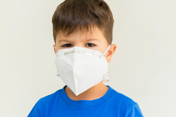 Closeup of caucasian boy wearing surgical mask. Face mask for protection against coronavirus outbreaks. Concept of protection against biological threat. Social isolation to prevent respiratory disease