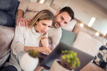 Poster - Couple using laptop at home.