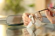 © PheelingsMedia - Woman hands cleaning glasses with tissue at home