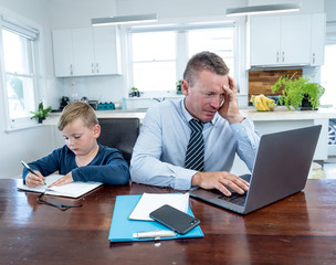 Wall Mural - COVID-19 school lockdowns and remote working. Stressed man trying to work from home with bored son