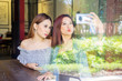 © Creativa Images - Beautiful young women taking selfie in cafe