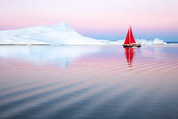 Wall Mural - sail boat with red sails cruising among ice bergs after sunset. disko bay, greenland.