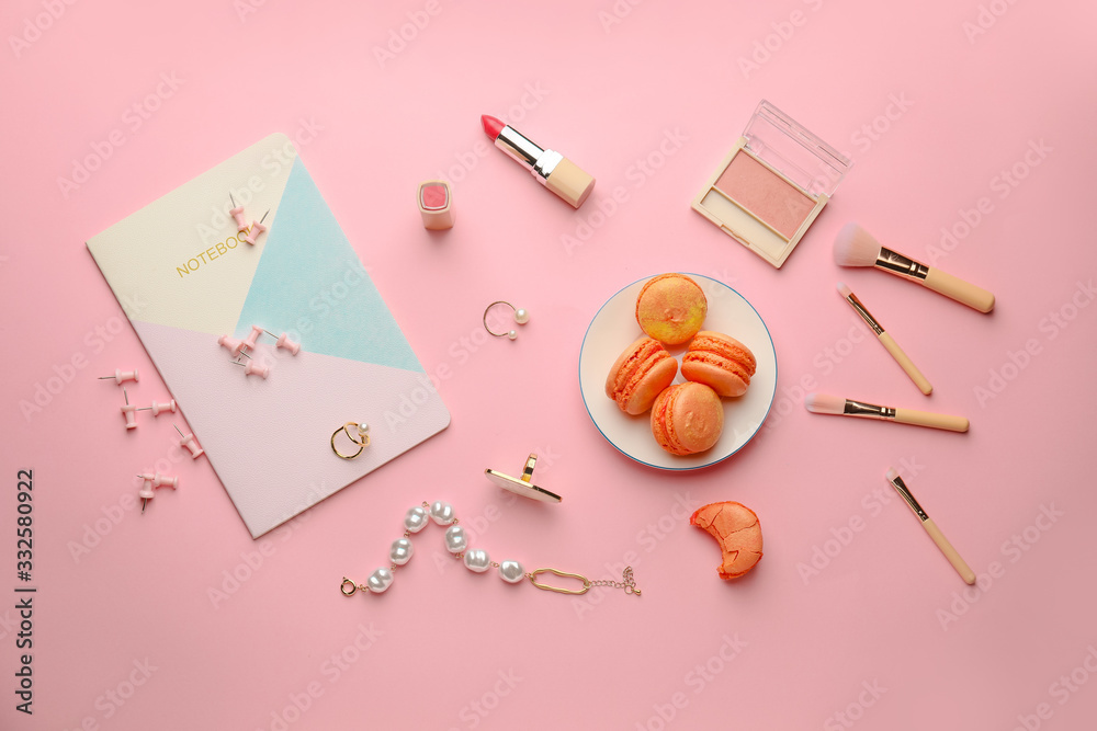 Makeup cosmetics and accessories with tasty macarons on color background
