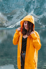 Wall Mural - woman in yellow raincoat at lake beach in tatra national park