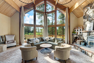 Amazing living room with three story tall vaulted wooden ceiling, huge windows, two large round chandeliers, venetian plaster, open staircase, beautiful design.