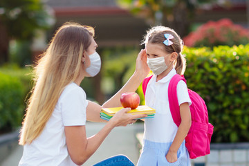 Child, mother wearing face mask going to school.