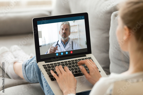 Cuadros en Lienzo Young woman sit on couch at home have video call with doctor use wireless intern