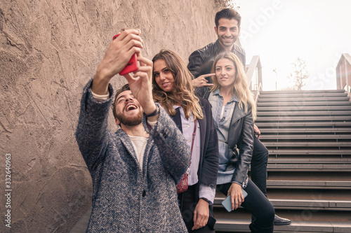 Group of fashion blogger trendy influencers taking a selfie outdoors. Young people having fun taking a picture together for their social media profiles.