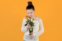 Girl Sadly Looks At Withered Flowers