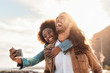 © Alessandro Biascioli - Happy smiling couple taking selfie with mobile smartphone outdoor - Young trendy people having fun during vacations - People technology addicted and travel trend lifestyle concept