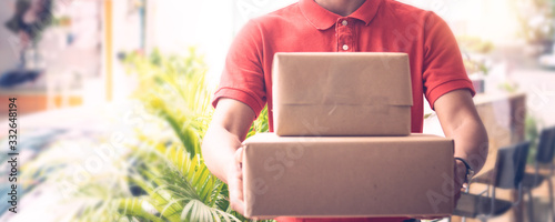 Fotomural Delivery man by sending box of parcel to customers service at home as having cor