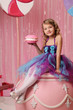 portrait of a girl-model, having fun at a birthday party in a beautiful, delicious, pink candy interior, the concept of themed children's holidays, participation in competitions.