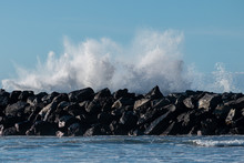 Rock Groyne Or Breakwater In The Sea, Pounded By Powerful Waves, Protecting The Beach Area
