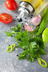 Wall Mural - Background spices, herbs and greens. Selection of spices, herbs and olive oil on a stone table.