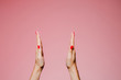 Woman's hands with bright manicure isolated on pink background big sign gesture