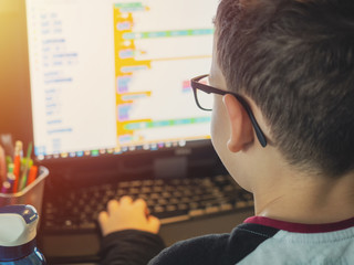 smart young boy works on a pc for his new project in his computer science class