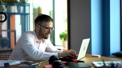 Inspired male blogger in classic spectacles for vision protection using computer technology for create interesting content publication and share to social people, talented smart casual freelancer 