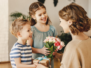 Wall Mural - happy children giving gift an flowers to mother.