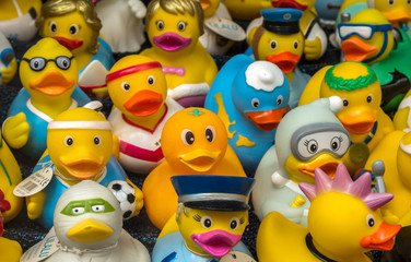 Collection of various rubber ducks in a shop window of a souvenir store.