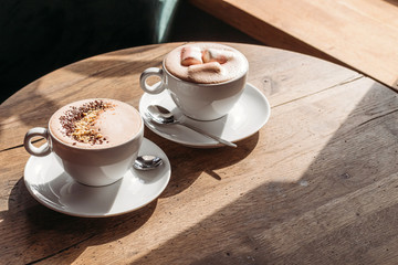 Cocoa in large white cup on table in cafe. Cocoa with marshmallows, peppers. Place for text.