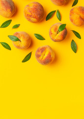 Wall Mural - Summer fruit background. Flat lay composition with peaches. Ripe juicy peaches with green leaves on yellow background. Flat lay top view copy space. Fresh organic fruit, vegan food. Harvest concept