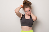 Fototapeta  - Smiling young girl is engaged in fitness. Teen girl in sportswear. Sport girl in tank top for yoga.