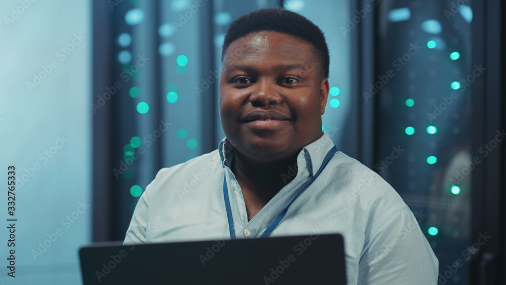 African american system administrator using laptop working in digital ...