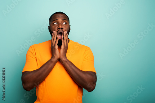 Cuadros en Lienzo Amazed and shocked expression of a boy over cyan background