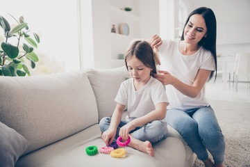 Poster - Happy sweet adorable two people loving mommy make haircut ponytail brush comb her little kid daughter sit crossed legs bare foot in apartment indoors