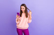 © deagreez - Photo of pretty addicted blogger lady holding telephone texting friends playing with long curl wear casual fur fluffy pullover trousers isolated purple color background
