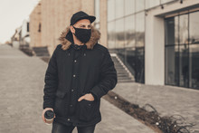Men Wears A Black Protective Medical Face Mask Being In The City During A Coronavirus Pandemic. Protection From Viruses In The City.