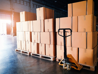 Wall Mural - Interior of storage warehouse. Stack of pakaging boxes on pallets and hand pallet truck. Shipment boxes. Supply chain Shipping warehouse logistics and transportation.