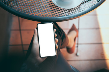 Mockup image blank white screen cell phone.woman hand holding texting using mobile on desk at coffee shop.background empty space for advertise text.people contact marketing business,technology