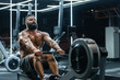 © Denys Kurbatov - Young strong bearded bodybuilder doing low cable pulley row seated