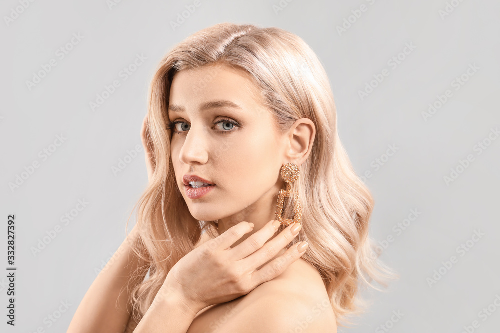Young blonde with beautiful hair on light background