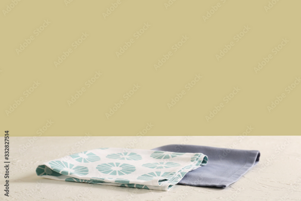 Napkins on table against color background
