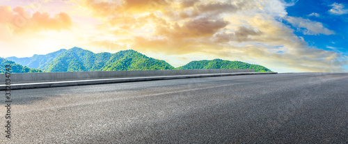 Fotomural Empty asphalt road and green mountain nature landscape at sunset.
